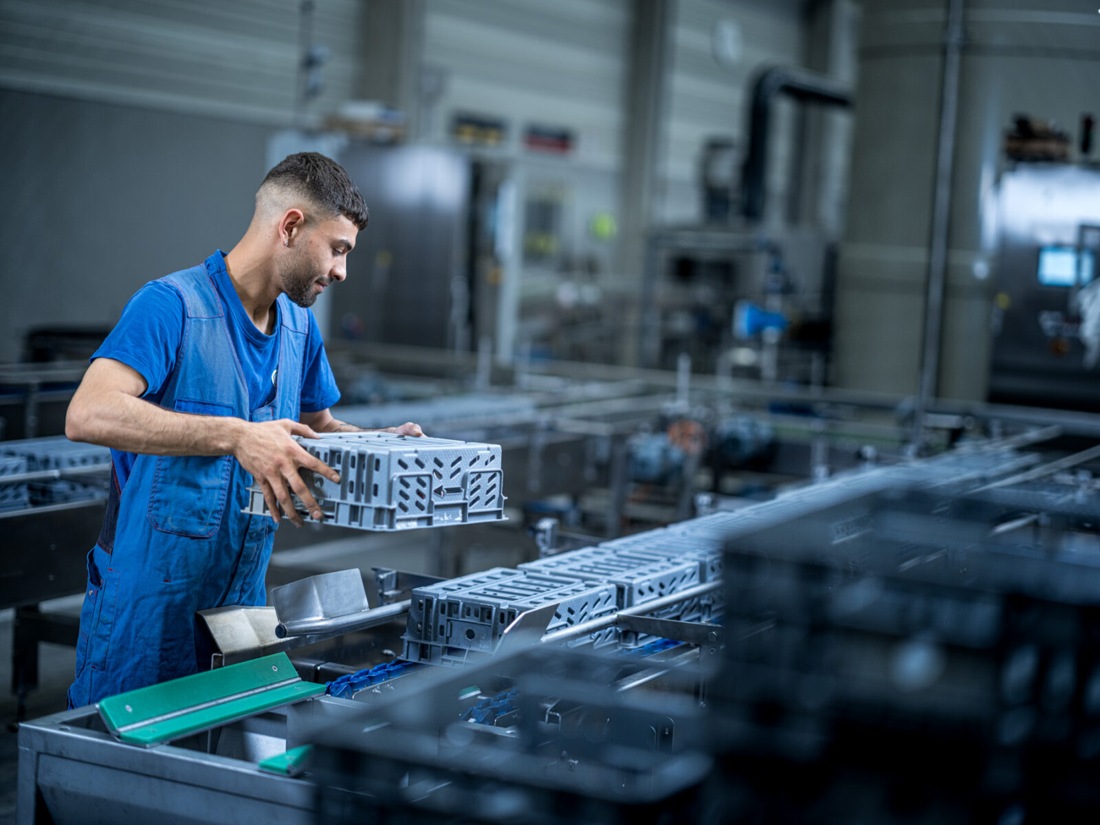 Employee adjusts machine in workshop