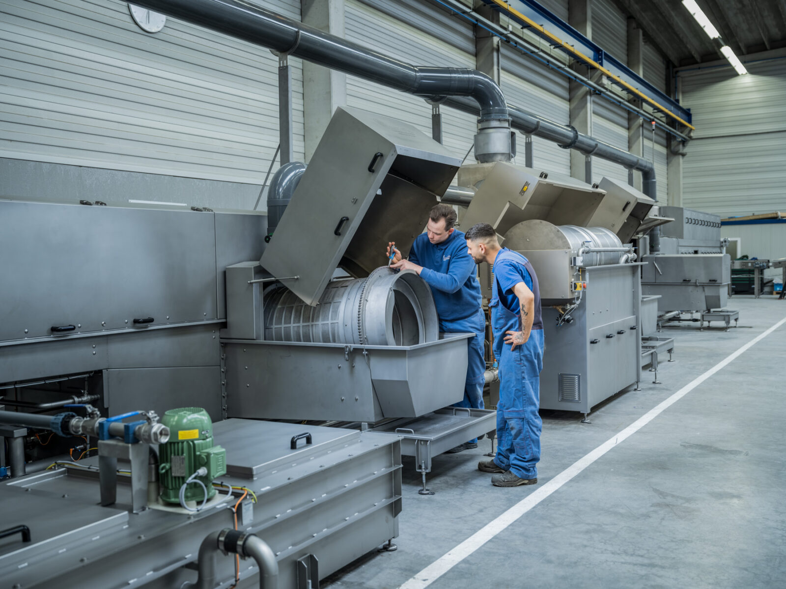 Employee adjusts machine in workshop