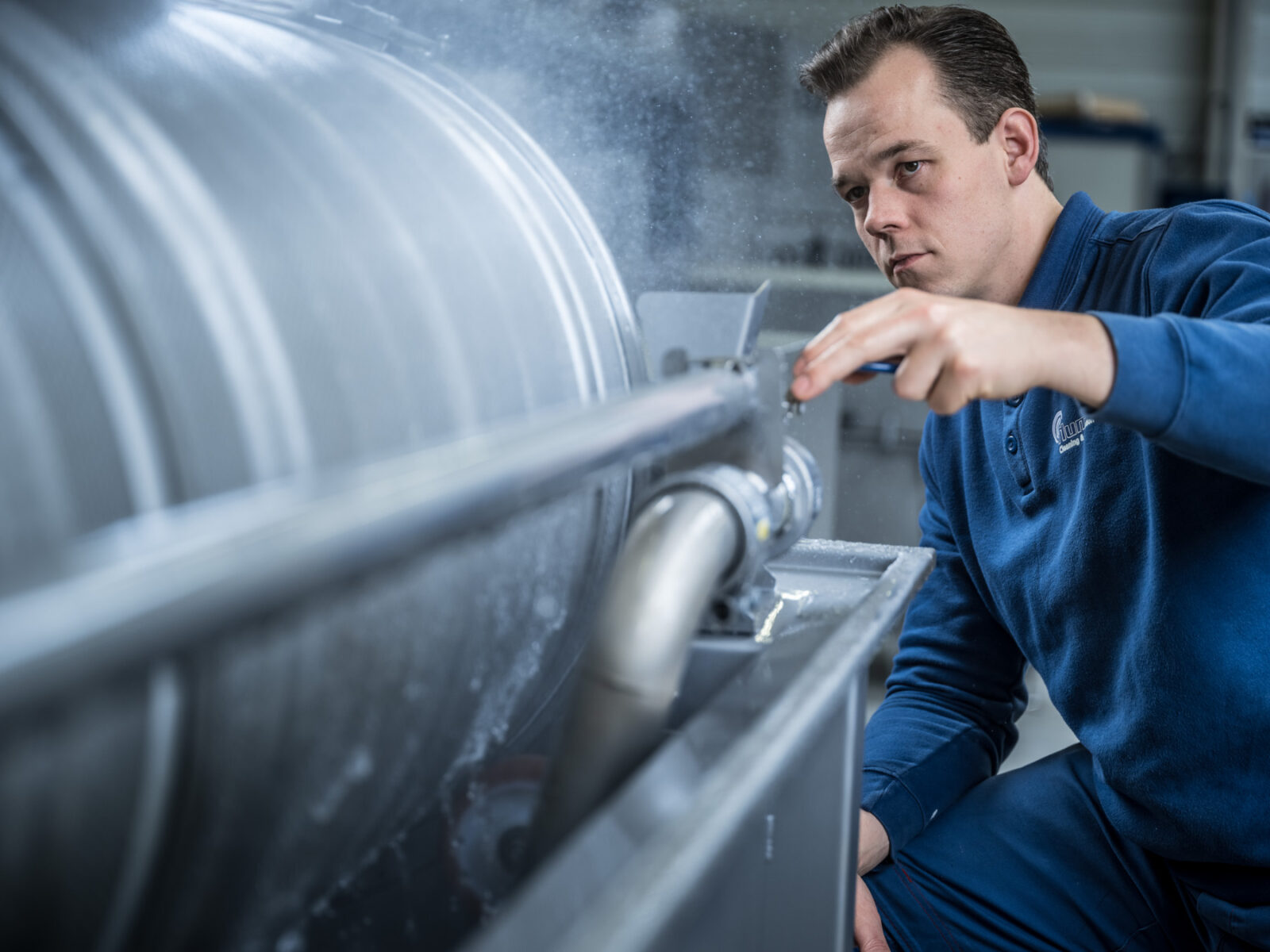 Employee adjusts machine in workshop