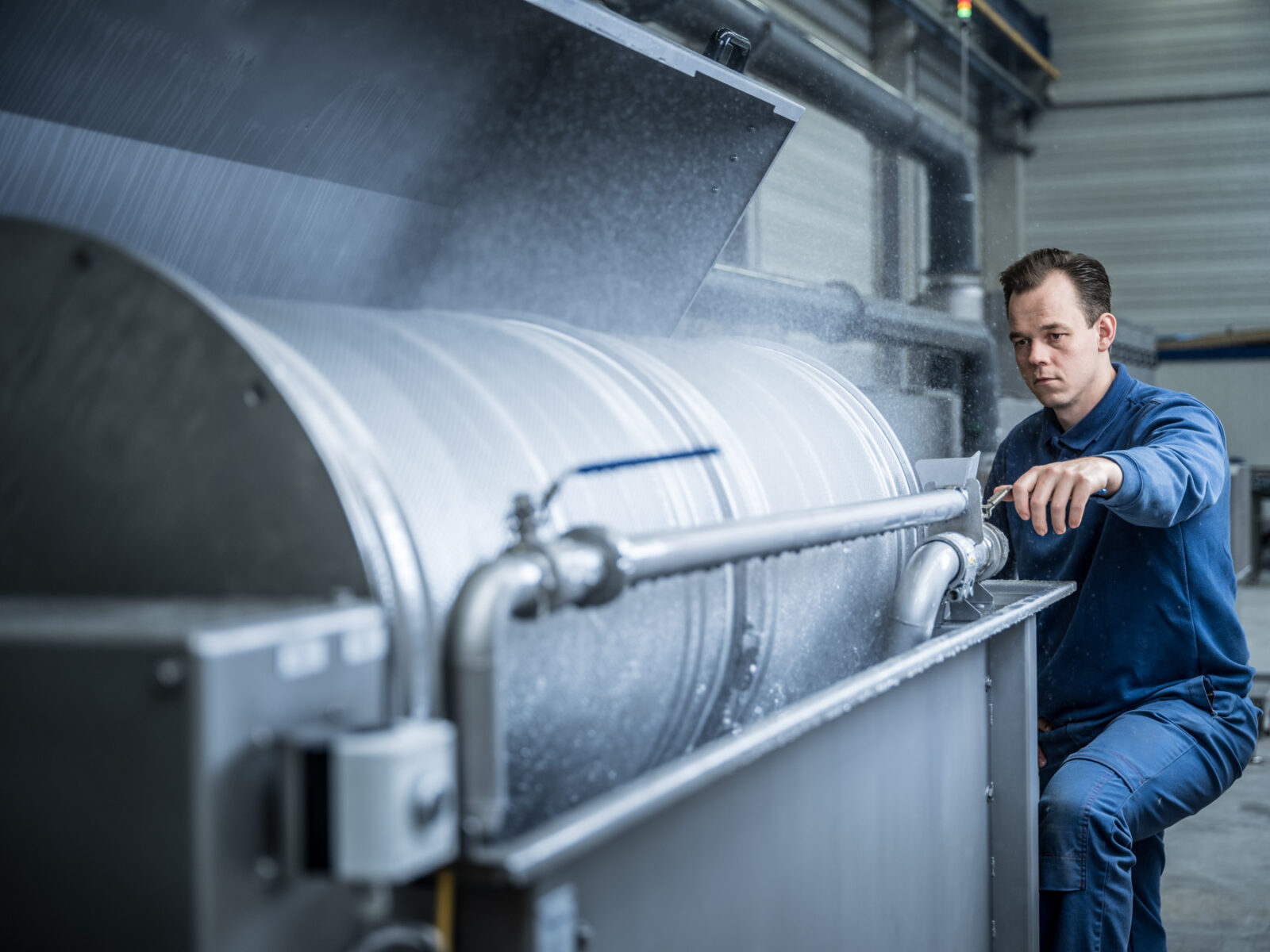 Employee adjusts machine in workshop