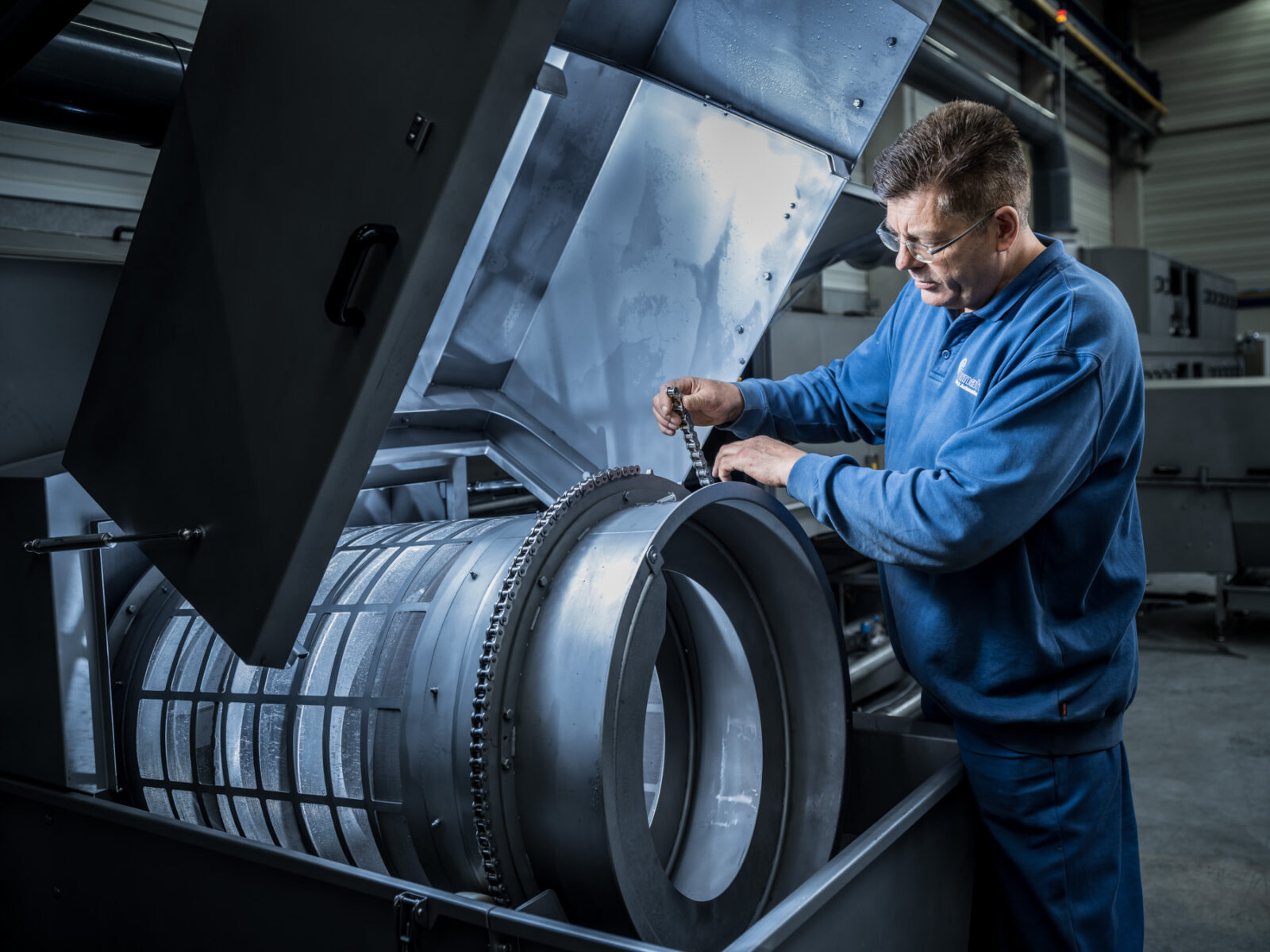 Employee adjusts machine in workshop