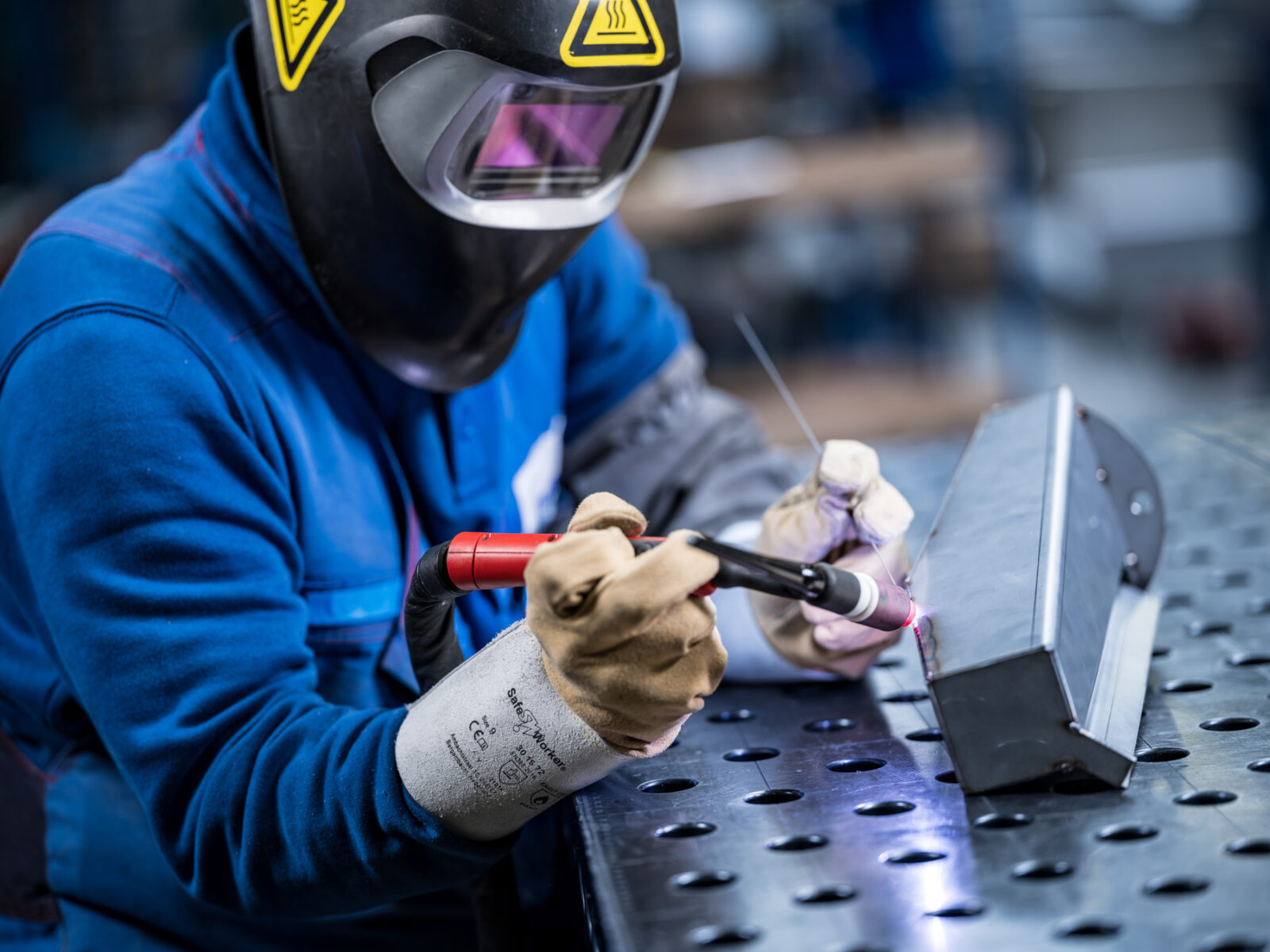 Employee adjusts machine in workshop