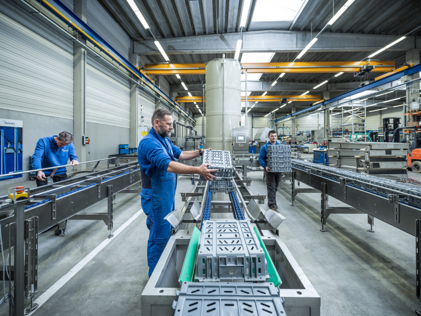 Medewerkers van Numafa met kratten bij een reinigingsoplossing